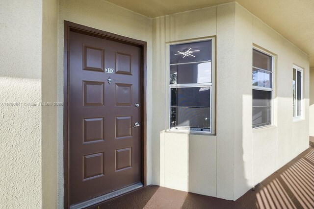 entrance to property featuring stucco siding