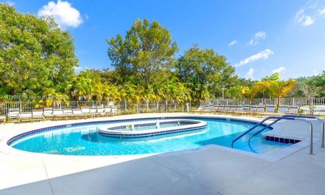 view of pool with a patio, a pool with connected hot tub, and fence