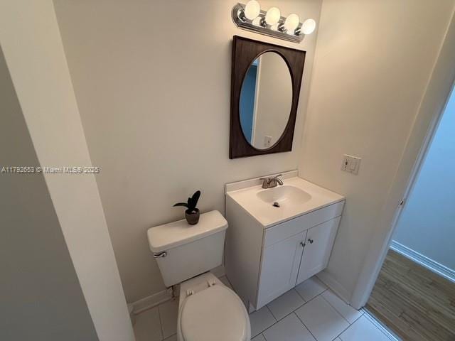 bathroom featuring vanity, tile patterned flooring, baseboards, and toilet