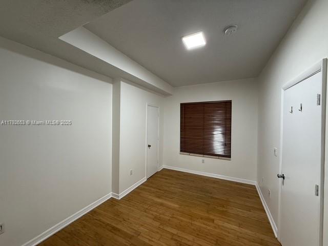 interior space with baseboards and wood finished floors