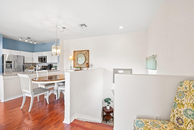 13127 SW 42nd St Unit 6203, Miramar, FL 33027 - interior space with backsplash, visible vents, appliances with stainless steel finishes, wood finished floors, and light countertops