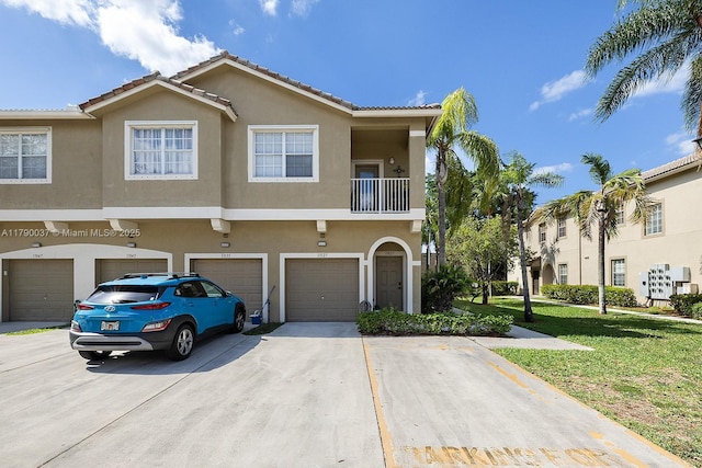 13127 SW 42nd St Unit 6203, Miramar, FL 33027 - view of property with a tiled roof, driveway, a front lawn, an attached garage, and stucco siding