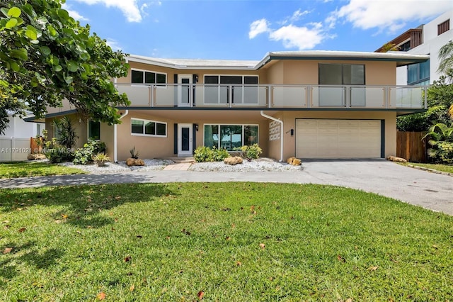 view of front of house with an attached garage, stucco siding, a front yard, concrete driveway, and a balcony