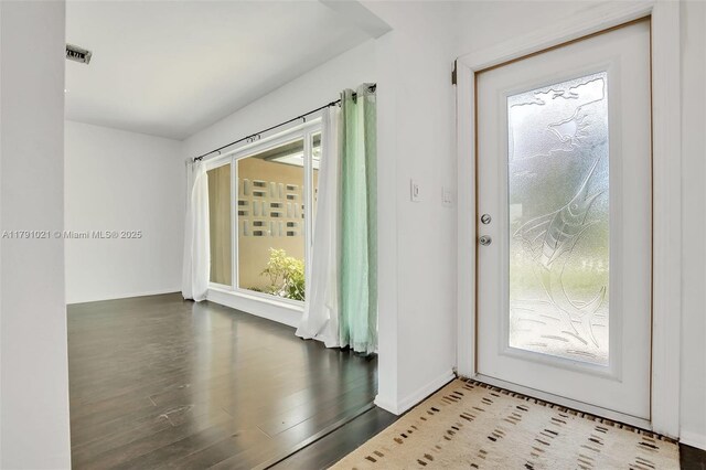 foyer entrance with baseboards, visible vents, and wood finished floors