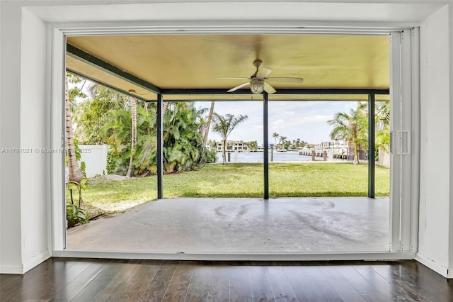 doorway with a water view, ceiling fan, and wood-type flooring