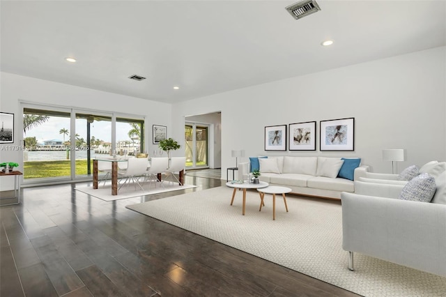 living area featuring recessed lighting, visible vents, and wood finished floors