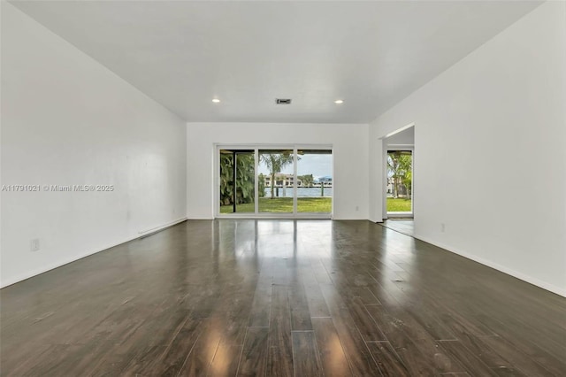 empty room featuring baseboards, visible vents, recessed lighting, and dark wood-type flooring