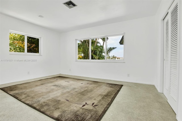 unfurnished bedroom with visible vents, baseboards, a closet, and multiple windows
