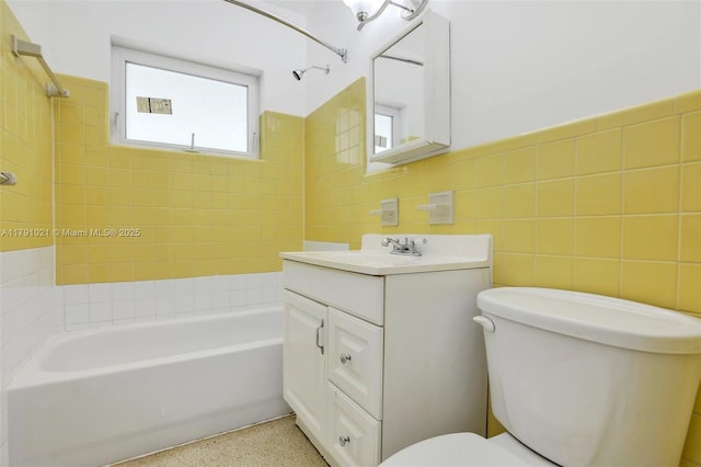 full bath featuring vanity, toilet, speckled floor, tile walls, and bathing tub / shower combination