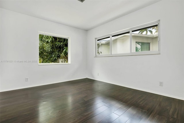 spare room featuring baseboards and wood finished floors