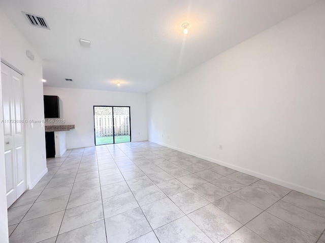 spare room with baseboards, visible vents, and light tile patterned floors