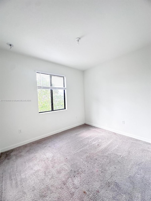 empty room with baseboards and carpet floors