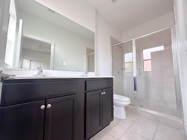bathroom featuring vanity, toilet, tile patterned floors, and a stall shower