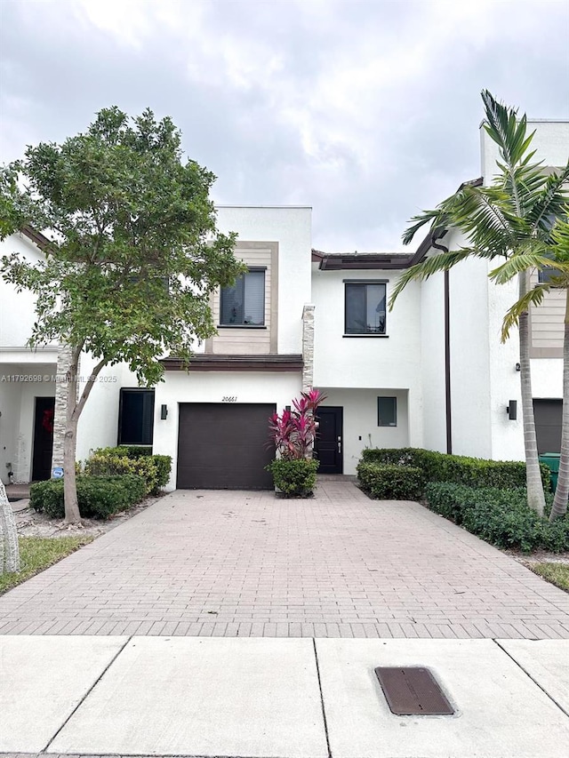 view of front facade with a garage, stucco siding, and driveway