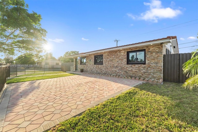 11981 SW 178th Ter, Miami, FL 33177 - back of house featuring a lawn, stone siding, fence, and a patio area