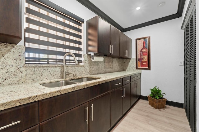 11981 SW 178th Ter, Miami, FL 33177 - kitchen featuring dark brown cabinetry, decorative backsplash, a sink, and light wood-type flooring