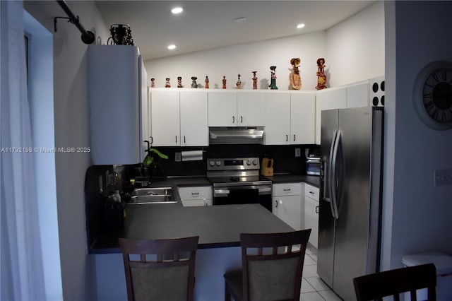 3240 W 70th St Unit 101, Hialeah, FL 33018 - kitchen with a peninsula, dark countertops, a breakfast bar, under cabinet range hood, and appliances with stainless steel finishes