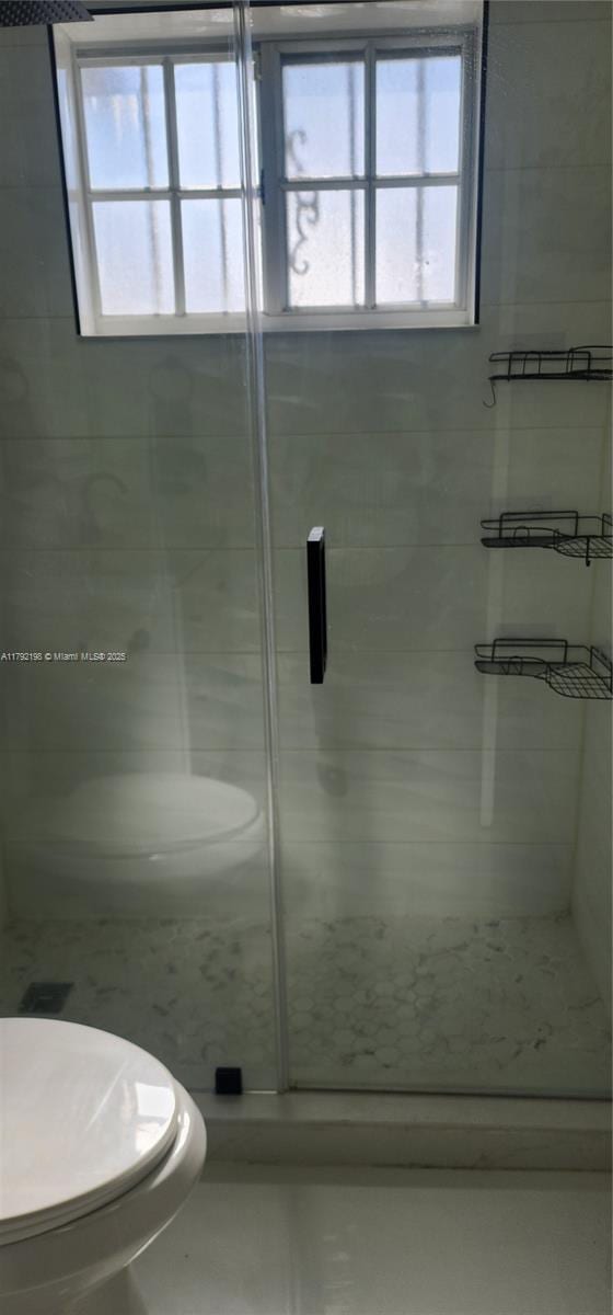 3240 W 70th St Unit 101, Hialeah, FL 33018 - bathroom featuring a stall shower, a wealth of natural light, and toilet