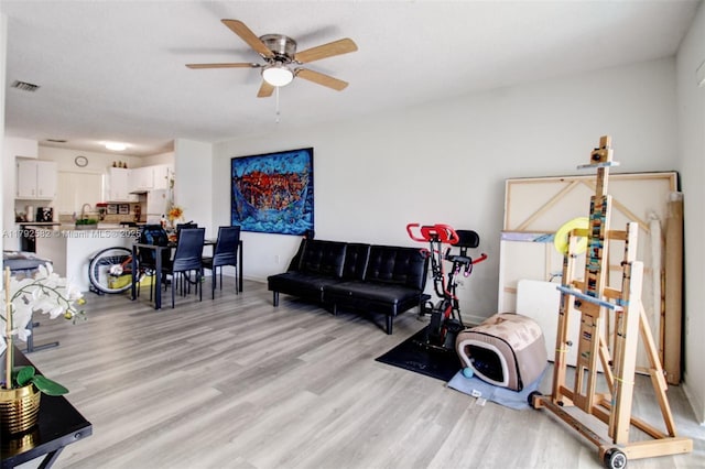 interior space with ceiling fan, visible vents, and light wood finished floors