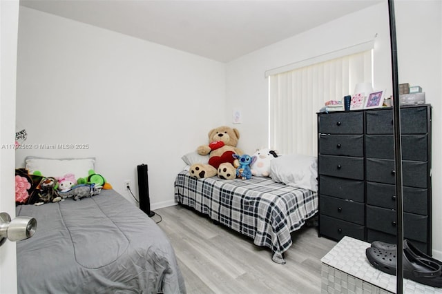 bedroom with baseboards and wood finished floors