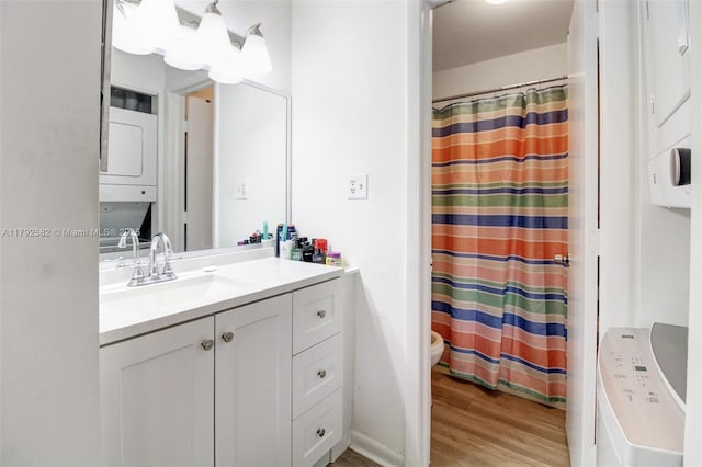 bathroom with vanity, stacked washer and clothes dryer, wood finished floors, and a shower with shower curtain
