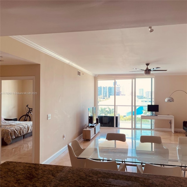 interior space featuring visible vents, ornamental molding, a wall of windows, baseboards, and ceiling fan