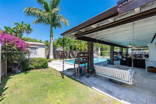 view of yard featuring outdoor lounge area, a fenced backyard, a fenced in pool, a ceiling fan, and a patio area