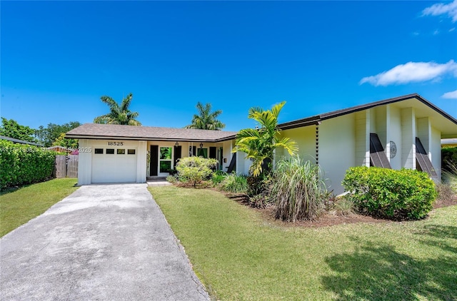 ranch-style home with a garage, a front lawn, aphalt driveway, and fence
