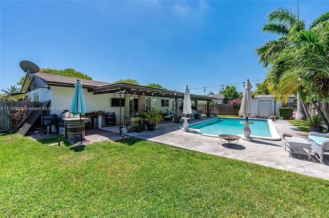 view of pool featuring an outdoor structure, a patio, a fenced backyard, a storage unit, and a lawn