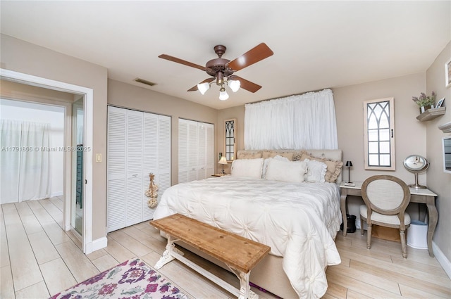 18525 SW 90th Ct, Cutler Bay, FL 33157 - bedroom featuring visible vents, multiple closets, baseboards, a ceiling fan, and light wood-style flooring