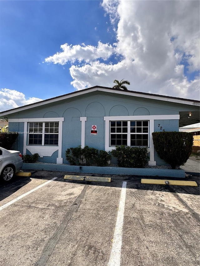 view of front of home with stucco siding and uncovered parking