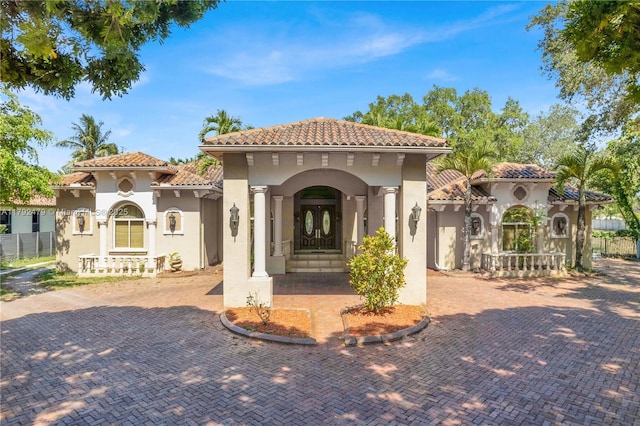 mediterranean / spanish house with stucco siding and a tiled roof