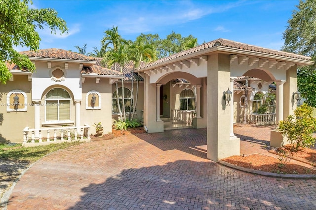 back of property with stucco siding and a tile roof