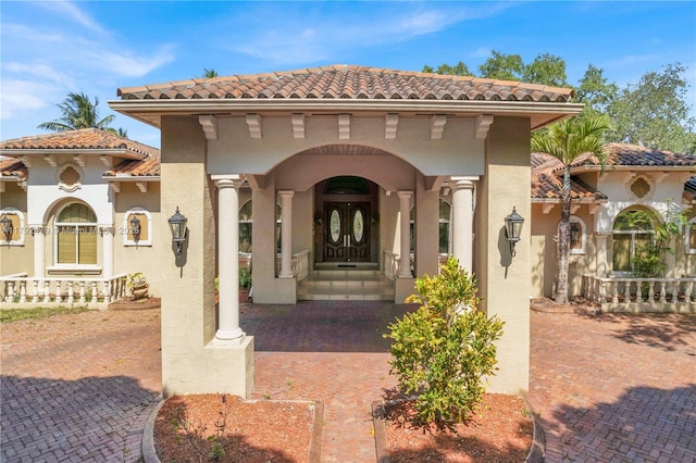 doorway to property featuring stucco siding and a tile roof