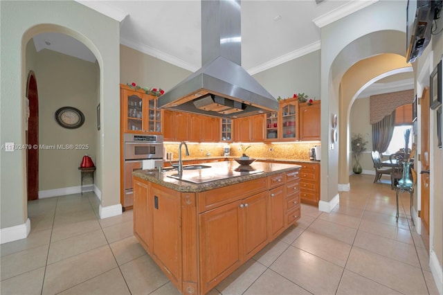 7761 SW 122nd Ave, Miami, FL 33183 - kitchen with island range hood, arched walkways, backsplash, ornamental molding, and a kitchen island with sink