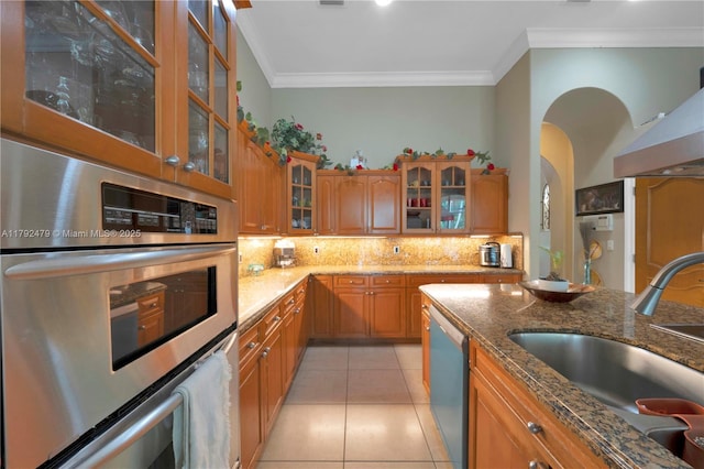 7761 SW 122nd Ave, Miami, FL 33183 - kitchen featuring dishwasher, stainless steel oven, a sink, brown cabinets, and arched walkways