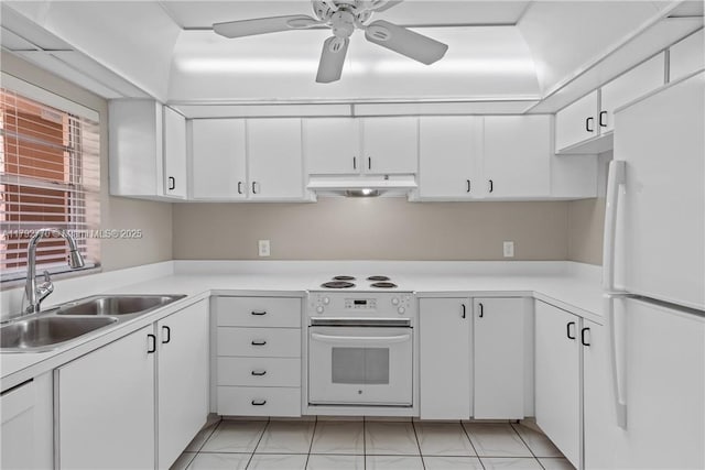 kitchen with a sink, white cabinets, freestanding refrigerator, under cabinet range hood, and oven