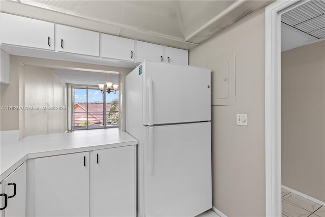 kitchen featuring freestanding refrigerator, white cabinetry, baseboards, and light countertops