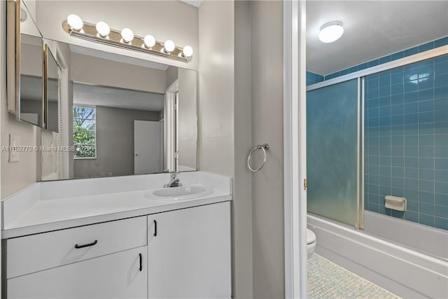 full bathroom featuring tile patterned flooring, bath / shower combo with glass door, toilet, and vanity