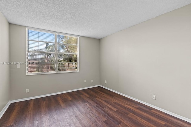 unfurnished room with a textured ceiling, baseboards, and wood finished floors