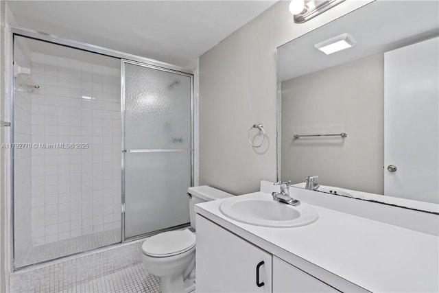 bathroom with vanity, toilet, tile patterned floors, and a stall shower