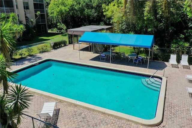 pool with fence and a patio