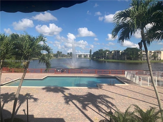 community pool with fence and a water view