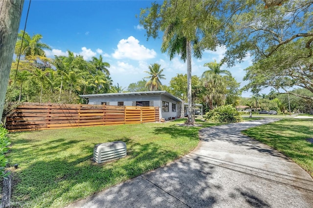 view of home's exterior featuring a lawn and fence