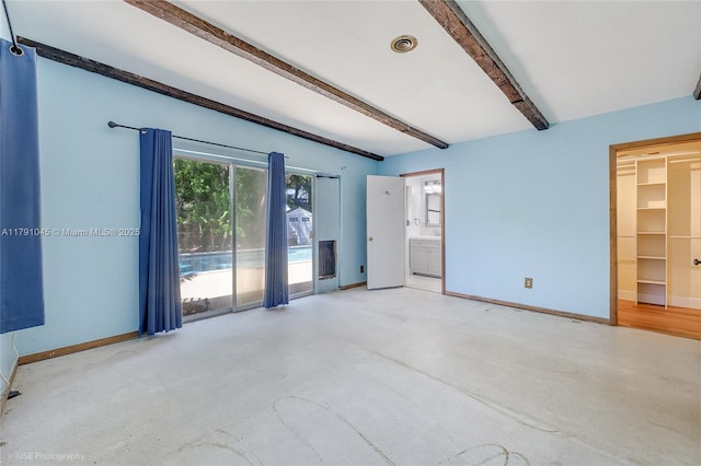 interior space with baseboards and beamed ceiling