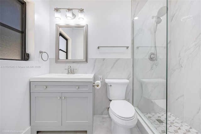 full bathroom with a marble finish shower, vanity, and toilet