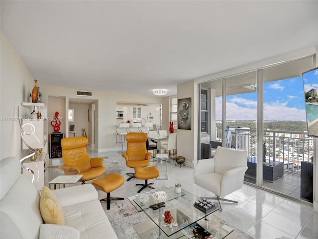 living room with visible vents, floor to ceiling windows, and tile patterned flooring