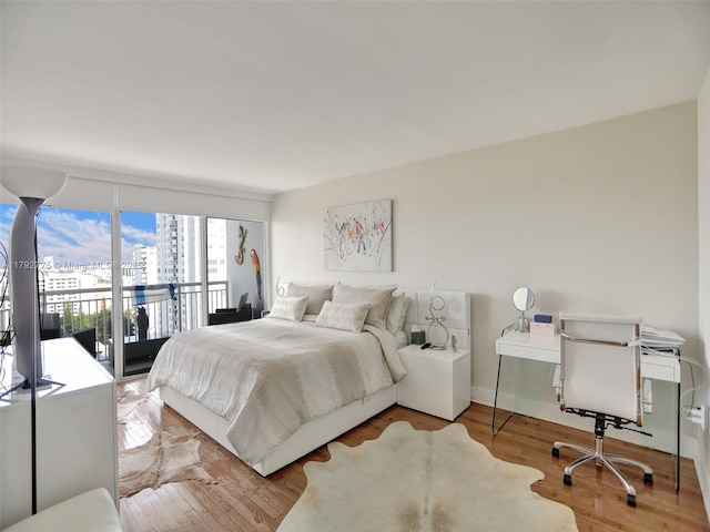bedroom featuring access to outside and wood finished floors