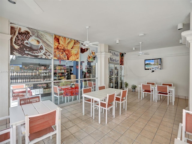 tiled dining space with decorative columns and a ceiling fan
