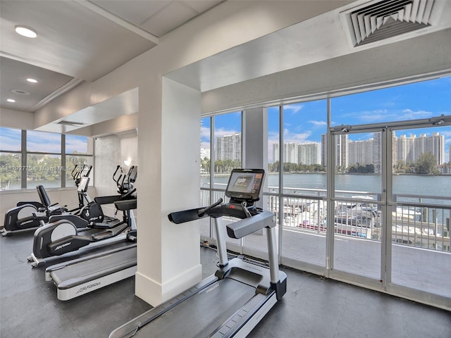 workout area with a view of city, recessed lighting, baseboards, a water view, and visible vents